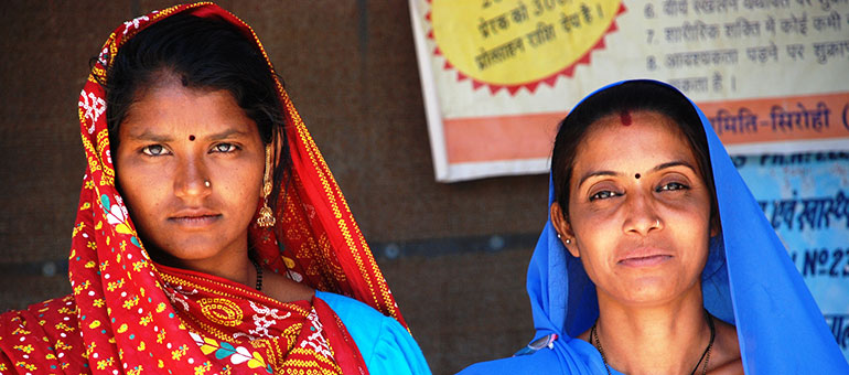 Two Indian women proudly look into the camera and smiling