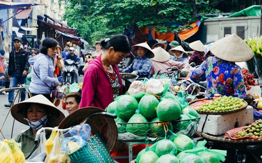 People in Hanoi market selling food and wearing typical hats