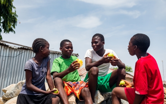 children eating fruits as they chat