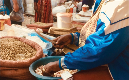 Woman Vendor Sorting Grains in Ethiopian Traditional Market