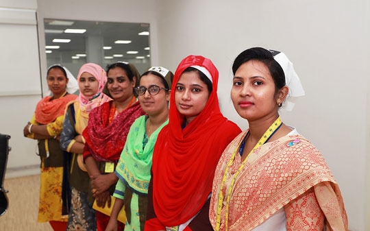 Garment factory workers smiling to the camera in line
