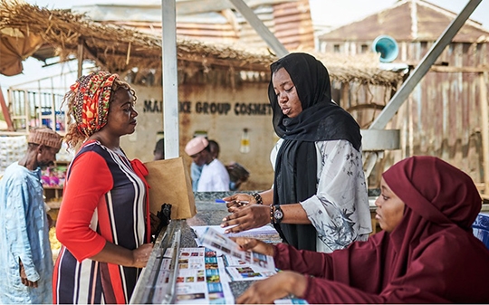 three female vendors speaking at a stall