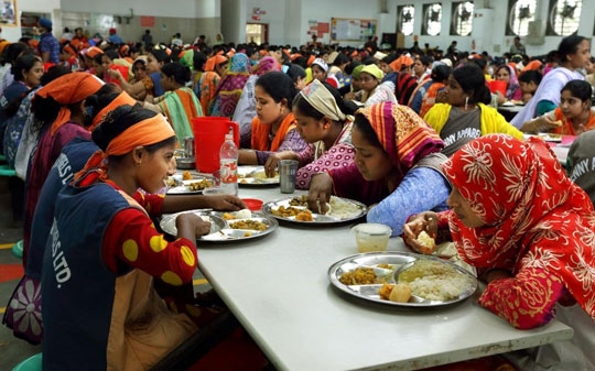 Women eating at a table in colorful clothes in India