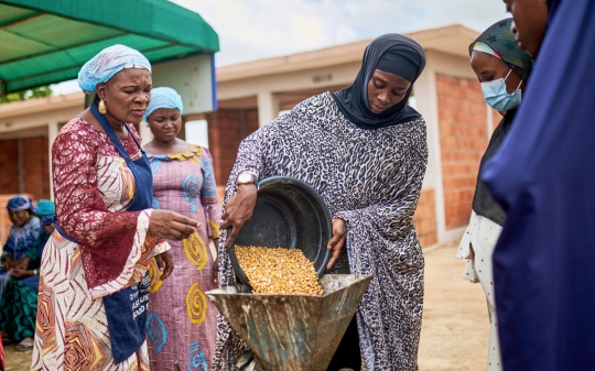 woman-putting-maize-into-processor