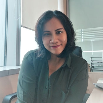 Christina smiling to the camera at her desk