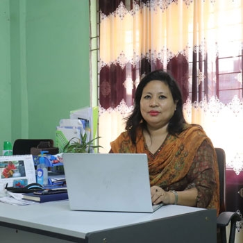 Daina sitting at her desk and typing on a laptop